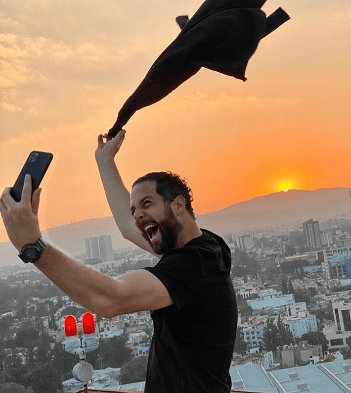Bernardo Feta celebrando con energía en azotea al atardecer